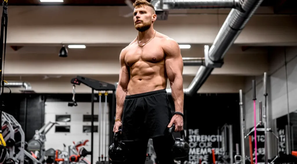 topless muscular man performing fat loss exercises with a kettlbell exercise