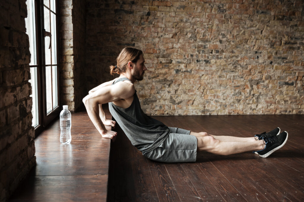 side view of a sportsman doing exercises at the windowsill